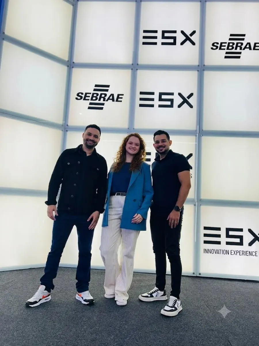 Fundadores da Deppes, Críslei Rodrigo, Marianna Santos e Mateus Carvalho, no ESX Innovation Experience, evento de inovação, com os painéis ESX e SEBRAE ao fundo